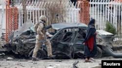 阿富汗安全部隊成員檢查喀布爾一處爆炸現場被炸毀的汽車。(2020年12月20日)