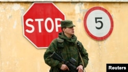 一位被認為是俄羅斯士兵的穿軍服的人守衛在烏克蘭在塞瓦斯托波爾的軍事基地外