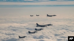 韩美日三国实施联合空中演习，旨在反制朝鲜上月31日发射“火星炮-19”型洲际弹道导弹。图为2023年12月20日，美国空军B-1B轰炸机、F-16战斗机、韩国空军F-15K战斗机和日本空军F-2战斗机再一起的联合演习中飞越韩国南部济州岛。(韩国国防部提供／美联社发布)