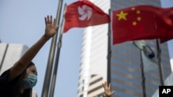 在香港和中國旗幟下香港抗議者伸出手掌表示五大訴求缺一不可。