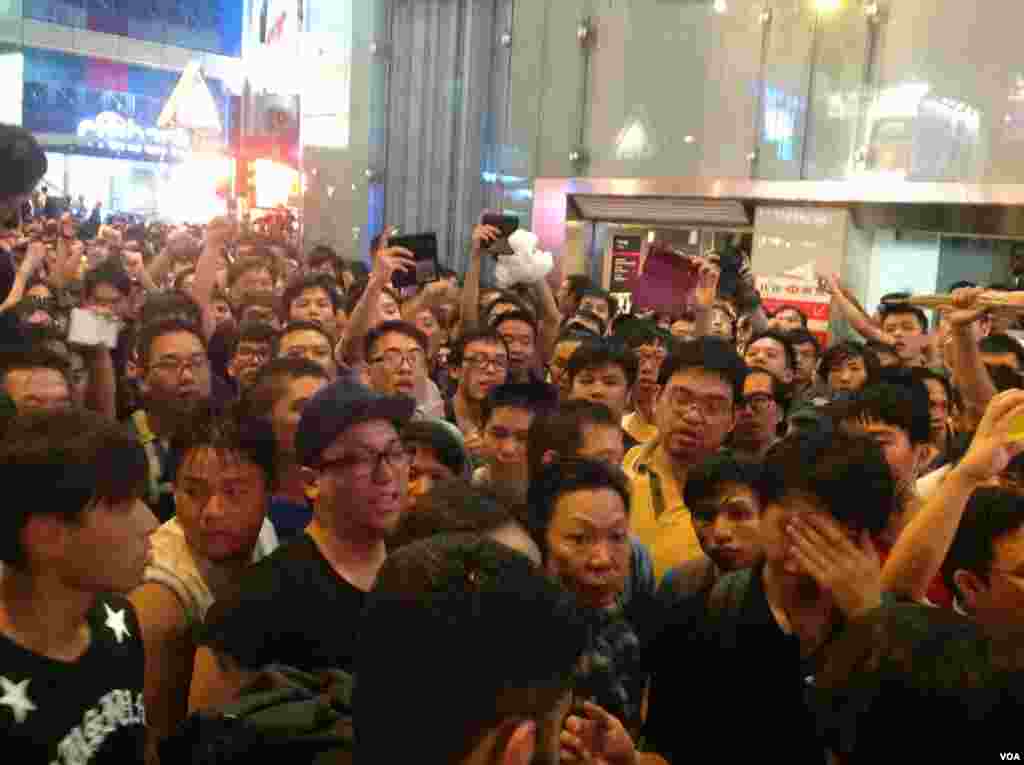 旺角现场少数戴蓝色丝带的反占中人士被支持学生的市民包围，市民指责他们推打学生，要求警方逮捕打人者(美国之音海彦拍摄)