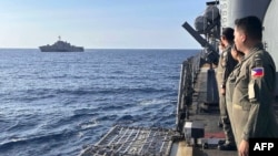 在有爭議的南中國海舉行的一次海上合作活動期間，菲律賓海軍葛雷戈里奧·德爾·皮拉爾級巡洋艦上的海軍軍官向途經的美海軍加布里埃爾·吉福茲號航空母艦致意。（2024 年2月9日）