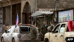 2024年12月12日，俄羅斯士兵站在軍用卡車旁，準備撤離敘利亞準備撤離敘利亞東北部卡米甚利(Qamishli)的陣地。