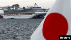 日本旗幟和在橫濱港停靠的鑽石公主號遊輪。 （路透社照片，2020年2月12日）