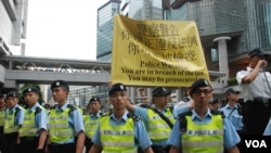香港警方高舉標語，警告參與學民思潮平反六四遊行的人士，可能被刑事檢控 (美國之音特約記者湯惠芸拍攝)