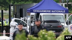A forensic worker looks for evidence as police officers patrol the site of an attack on a prison van at a road toll in Incarville, France, on May 14, 2024.