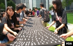 示威者在香港特區政府總部外的草地展開一幅巨型黑布，上面貼有10萬個反對國民教育的市民簽名