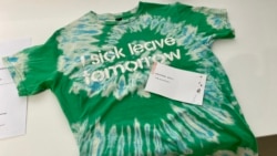 香港市民Phoenix 在反送中運動兩周年義賣活動，以物易物方式帶走一件喻意飲水思源的T恤。(美國之音 湯惠芸拍攝)