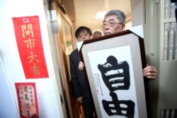 资料照：台湾台北铜锣湾书店创办人林荣基手持台湾公民参与协会理事长何宗勋写的“自由”字画。