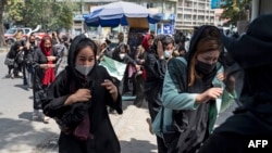 塔利班政府對阿富汗婦女施加了一系列限制；圖為利班武裝人員在喀布爾向空中開槍驅散阿富汗婦女抗議者。 (法新社：2022年8月13日)