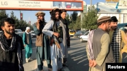 塔利班成員站在哈米德·卡爾扎伊國際機場外。(2021年8月16日)