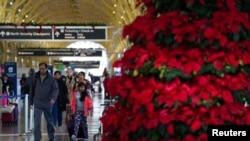 2022年12月20日，乘客在華盛頓裡根國家機場走過。全國大部分地區的冬季風暴可能會導致聖誕節假期的旅行延誤。（路透社照片）