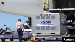 台灣工人在桃園國際機場從日本飛機上卸下日本捐贈的新冠病毒疫苗。 （2021年7月8日）