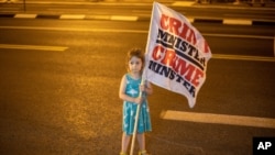 一個女孩9月6日星期天在總理官邸外的廣場的抗議活動中舉旗。