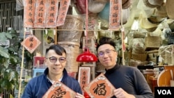 朱榮記老闆朱耀昌（左）與80後博客阿金連續第二年合作開設手寫揮春檔。(美國之音照片)