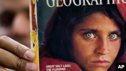 資料照片：巴基斯坦伊斯蘭堡一家書店展示的《國家地理》雜誌刊登的綠眼阿富汗女孩照片（2016年10月26日）