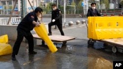 武漢市解除封鎖，幾名工作人員正在移除馬路上的障礙物。（2020年4月7日）