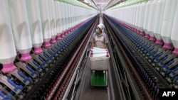 中國山東棗莊市一家紡織業工廠的工人在生產線上。（2024年12月15日）