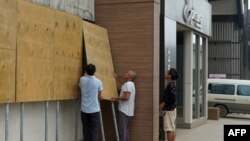 當地人在熱帶龍捲風哈羅德登錄瓦努阿圖首都維拉港前在商店門口假設防護板。（2020年4月6日）