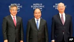 越南總理阮春福（中）、中國副總理胡春華（左）和世界經濟論壇執行主席施瓦佈在世界經濟論壇東盟會議上合影。（2018年9月12日） 