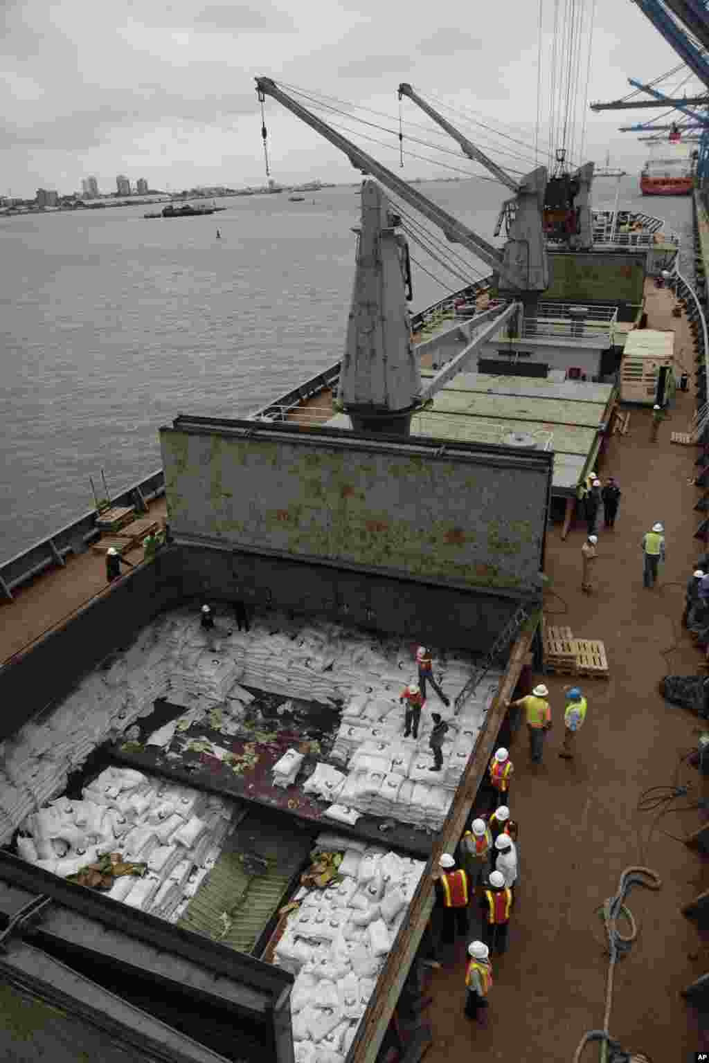 Panamanian workers stand atop sacks of sugar inside a container aboard a North Korean-flagged ship at the Manzanillo International container terminal on the coast of Colon City, Panama, July 16, 2013. 