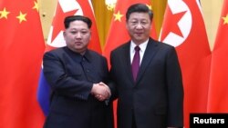 中共中央總書記、國家主席習近平和北韓勞動黨委員長、國務委員會委員長金正恩在北京人民大會堂握手（2018年3月28日發布的照片​​）