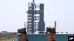 资料照：中国军人守卫在甘肃酒泉卫星发射中心的长征2F火箭和神舟十号宇宙飞船附近。（2013年6月11日）