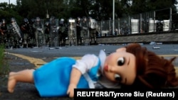 资料照：在香港民众反送中游行期间防暴警察堵住一个路口，路口躺着一个玩具娃娃。