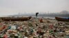 A fisherman walks on the shores of the Arabian Sea, littered with plastic bags and other garbage, in Mumbai, India.