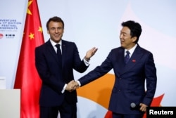 法國總統馬克龍在北京向在華法國人講話後與中國影星黃渤握手。（2023年4月5日）