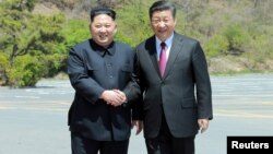 北韓領導人金正恩與中國國家主席習近平資料照。