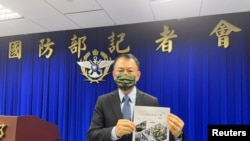 台灣國防部官員2023年6月13日展示最新版民防手冊。 （路透社）