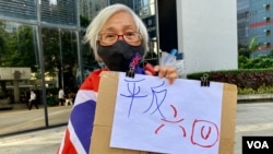 香港社运人士王婆婆11月1日在区域法院外手持标语，声援六四未经批准集结案的8名被告，包括前支联会主席李卓人、副主席邹幸彤及壹传媒创办人黎智英等 (美国之音/汤惠芸)