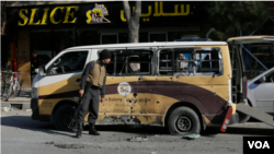 一名阿富汗安全官员检查在喀布尔火箭弹袭击严重损坏的汽车。(2020年11月21日)