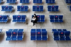 春节前夕一名乘客在北京南站候车室等车。（2021年2月10日）