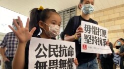 有家長帶同年幼的女兒到法庭外聲援15名被控非法集結等罪名的民主派人士。(美國之音湯惠芸)