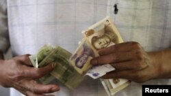 一位顾客在北京的一家银行数钱(资料照片)