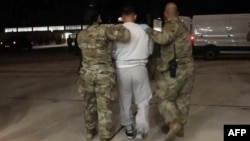 This screenshot from video provided by the U.S. Defense Department shows one of the detained migrants arriving at Naval Station Guantanamo Bay on Feb. 4, 2025.
