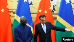 所羅門群島總理索加瓦雷和中國總理李克強在北京人大會堂舉行協議簽署儀式。（路透社2019年10月9日）