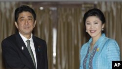 日本首相安倍晋三和泰国总理英拉1月17日在曼谷举行联合记者后合影。
