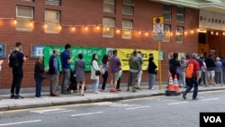 香港市民在灣仔區的軒尼詩道官立小學的投票站內排隊投票選舉該區議會的區議員。