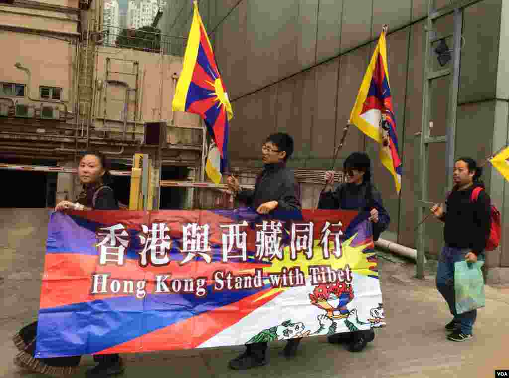 數名香港與西藏同行成員身穿黑衣，由中聯辦遊行到銅鑼灣，以示支持藏人爭取自治