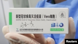 在中国政府组织的访问期间，一名护士在北京的疫苗接种中心拿着一盒北京生物制品研究所生产的冠状病毒病 (COVID-19) 疫苗。（2021年4月15日）