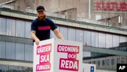 瑞典民粹主義政黨瑞典民主黨的成員2018年8月30日在斯德哥爾摩擺放競選標語。