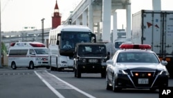 一輛據信載有鑽石公主號遊輪乘客的大巴車在警車開道下離開日本橫濱港。 （2020年2月19日）