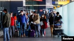 资料照片: 旅行者带着行李走在意大利的菲乌米奇诺机场。(2021年5月17日)