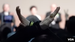 示威者在香港特首選舉點票中心高舉交叉手勢。(美國之音湯惠芸)