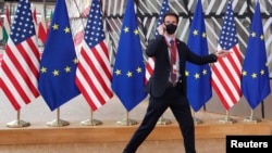 布魯塞爾歐盟總部內，一名保全人員從美國和歐盟旗幟前走過。 （2021年6月15日）