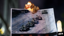 資料照：在香港維多利亞公園參加紀念六四事件31週年的一名男子手持天安門廣場“坦克人”的照片。（2020年6月4日）