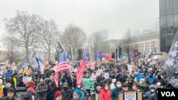 大約三千示威者在英國時間2月8日星期六下午在舊皇家鑄幣廠前示威，抗議中國當局計劃在該地段興建新的駐倫敦大使館。有示威者手持香港人在2019年反送中運動期間的“光時旗”（光復香港，時代革命）和美國國旗參加抗議。（攝影：美國之音鄭樂捷）